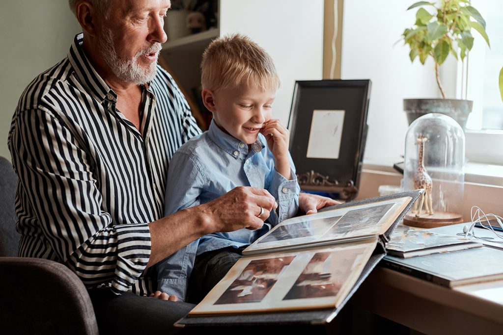 A grandparent and child looking at a photo album